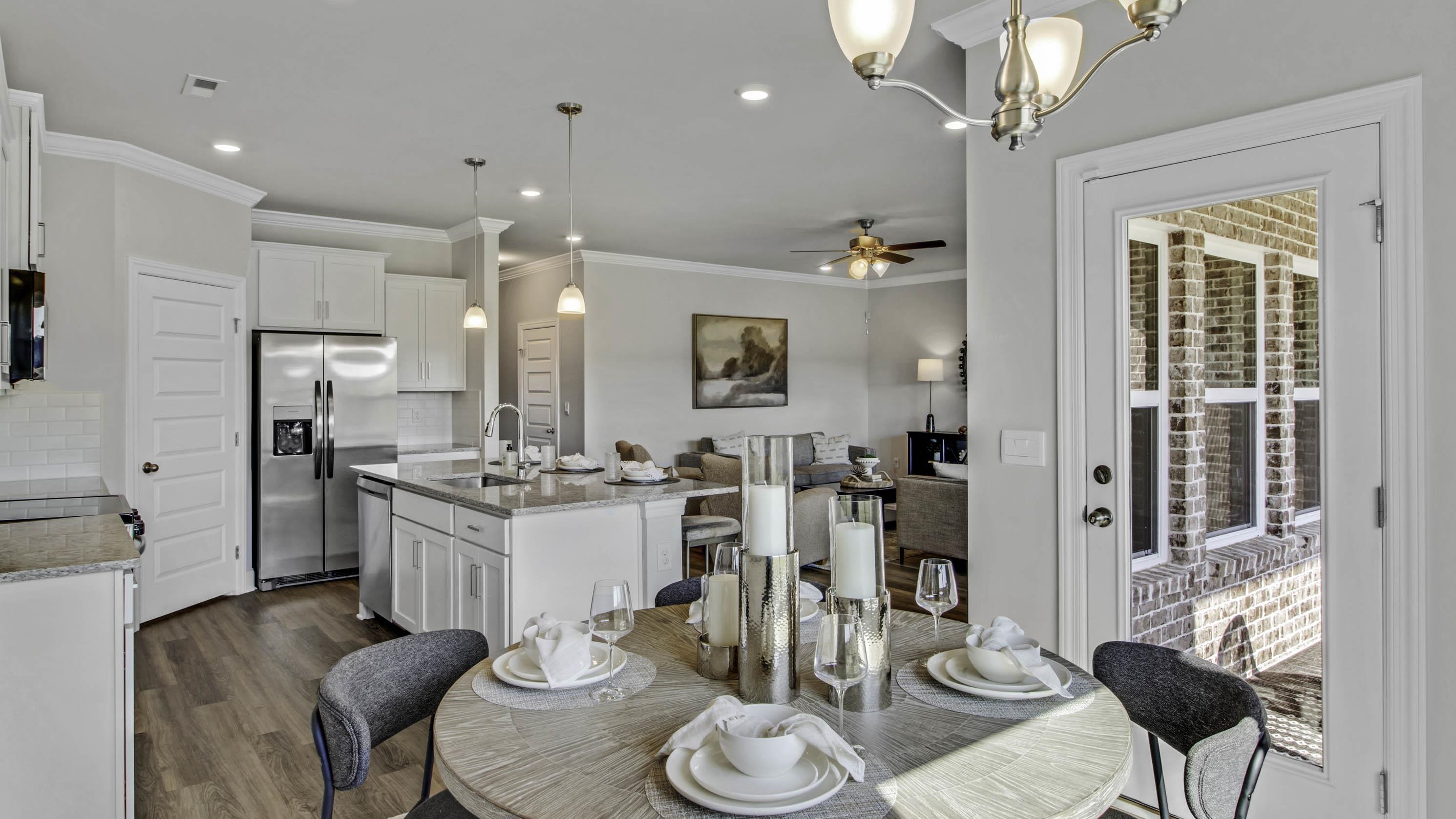 1010 Mewborn Farm Road Oakland, TN 38060 - Photo 12 of 40 a kitchen with stainless steel appliances kitchen island granite countertop a refrigerator a stove a dining table and chairs with wooden floor
