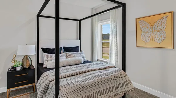 a bedroom with a large bed and a painting on the wall