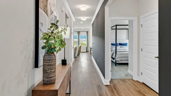 a view of a hallway with wooden floor and stairs
