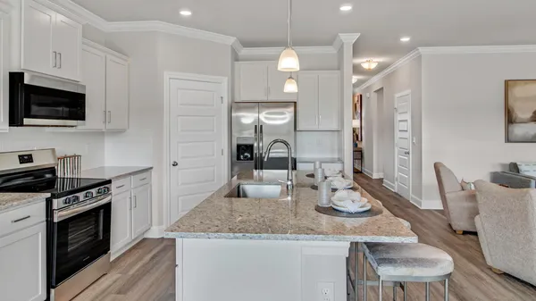 a kitchen with granite countertop stainless steel appliances a stove sink microwave and cabinets