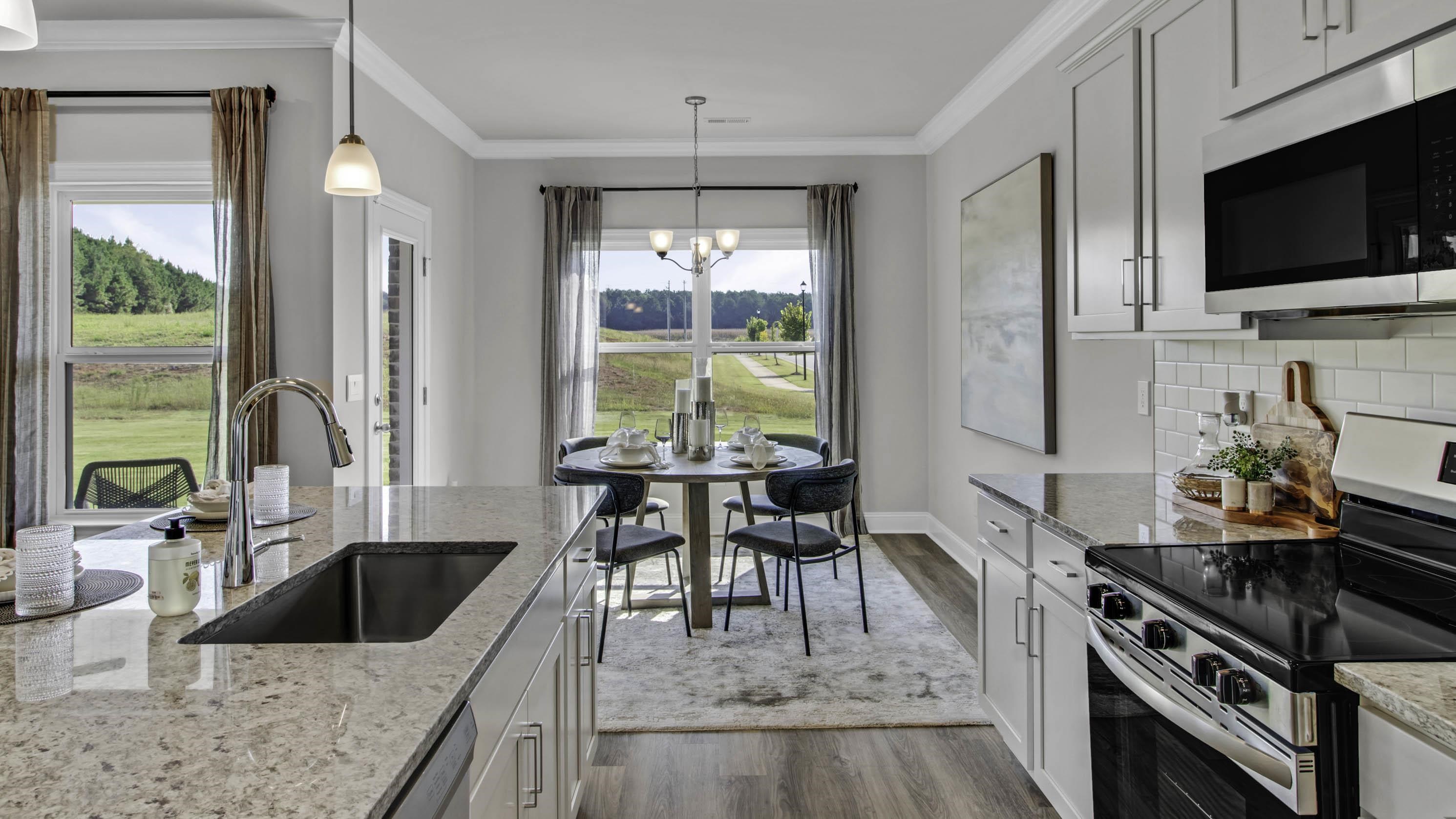 1010 Mewborn Farm Road Oakland, TN 38060 - Photo 6 of 40 a kitchen with stainless steel appliances granite countertop a stove top oven a sink a dining table and chairs with wooden floor
