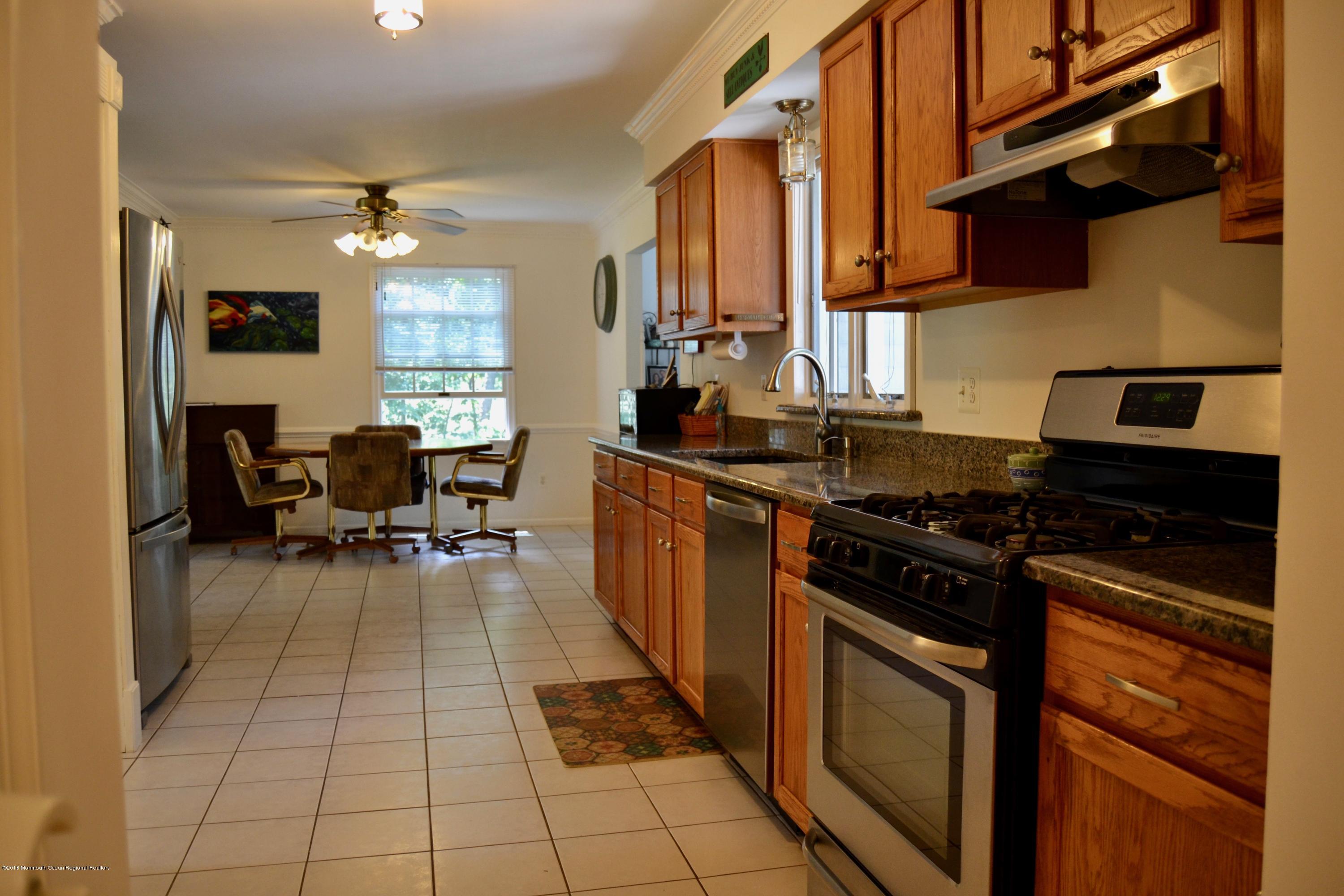3087 Ridgeway Boulevard Manchester Township, NJ 08759 - Photo 17 of 30 a kitchen with a stove a sink a dining table and chairs