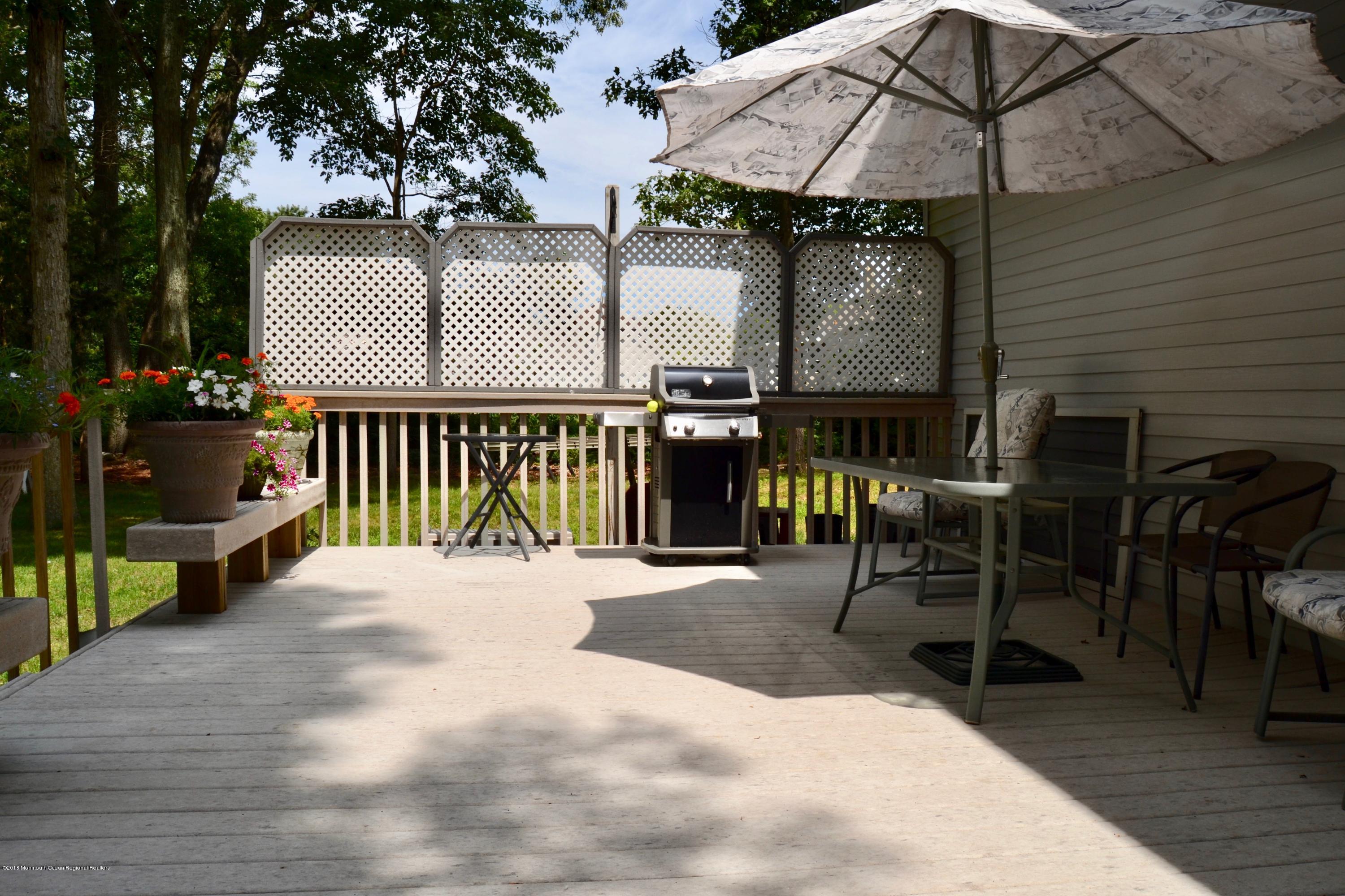 3087 Ridgeway Boulevard Manchester Township, NJ 08759 - Photo 8 of 30 a view of a patio with a table and chairs under an umbrella