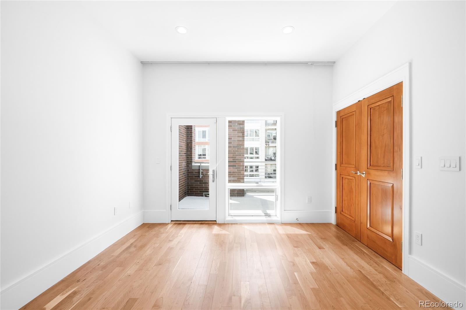 2133 18th Street Denver, CO 80202 - Photo 28 of 46 an empty room with wooden floor and windows