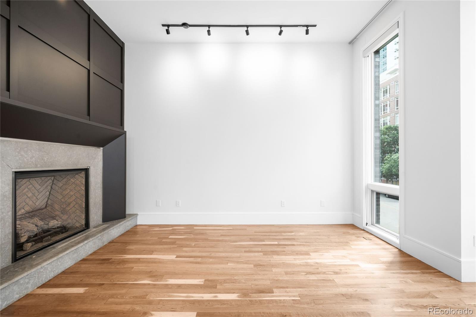 2133 18th Street Denver, CO 80202 - Photo 4 of 46 a view of an empty room with wooden floor and a fireplace