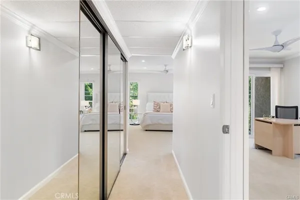 a view of a hallway with bathroom and wooden floor