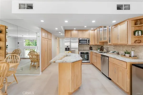 a kitchen with stainless steel appliances kitchen island granite countertop a sink and cabinets