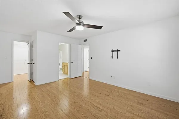 a view of empty room with wooden floor