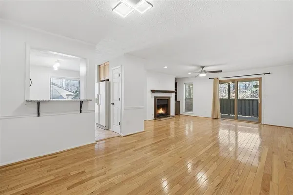 a view of empty room with wooden floor and fireplace