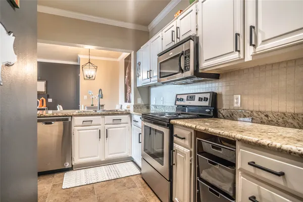 a kitchen with granite countertop stainless steel appliances a sink and counter space
