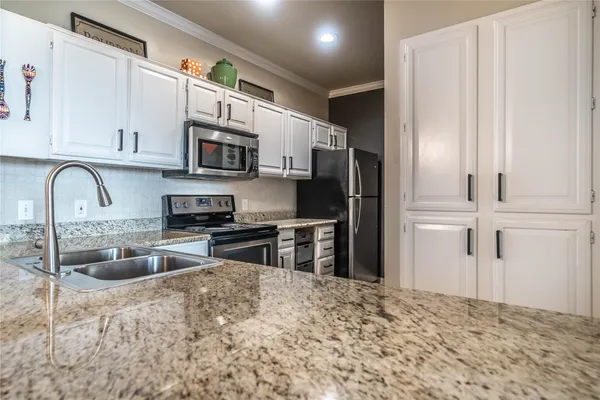 a kitchen with stainless steel appliances granite countertop a sink stove and microwave