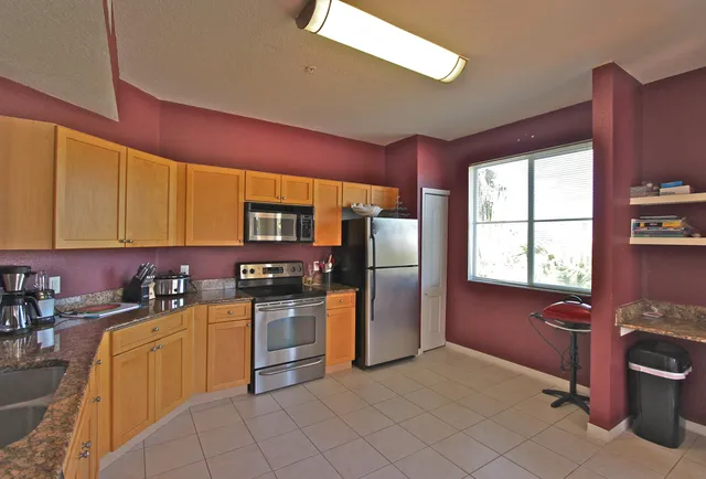 a kitchen with stainless steel appliances granite countertop a refrigerator and a stove
