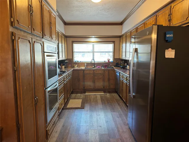a kitchen with stainless steel appliances a refrigerator and a window