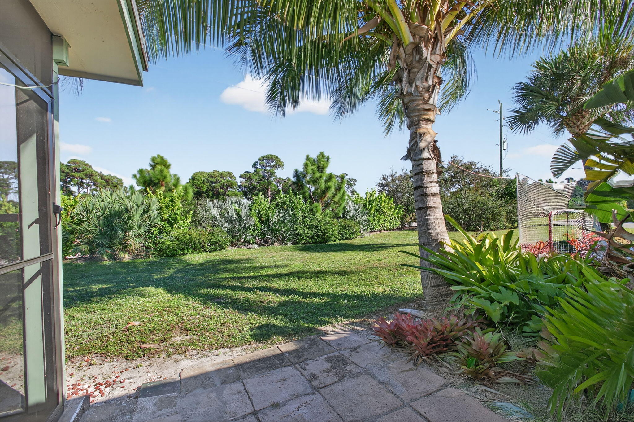 8695 Southeast Hobe Ridge Avenue Hobe Sound, FL 33455 - Photo 29 of 29 a garden with trees in front of it