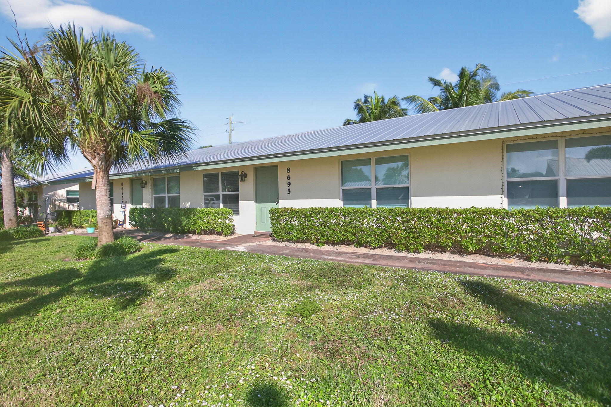8695 Southeast Hobe Ridge Avenue Hobe Sound, FL 33455 - Photo 3 of 29 a view of a house with a yard and potted plants