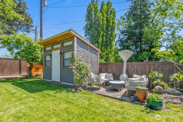 a view of a house with backyard and sitting area