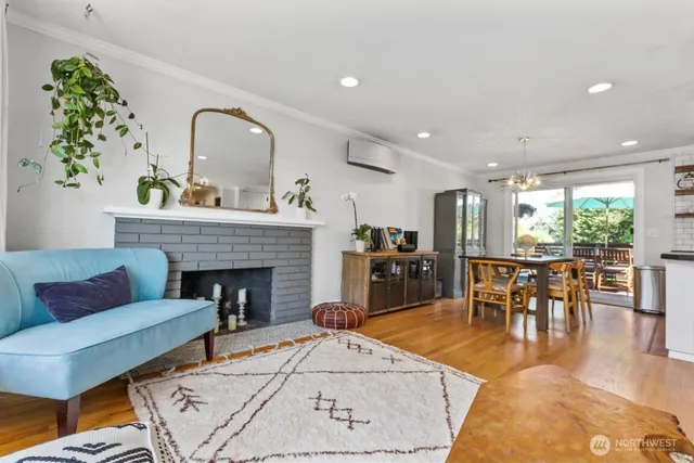 a living room with furniture a fireplace and a dining table with wooden floor