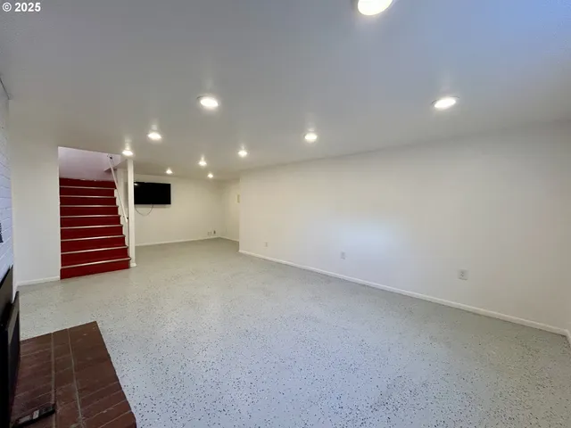 an empty room with wooden floor and stairs