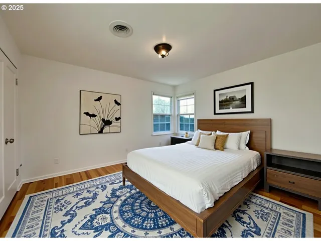 a bedroom with a bed and painting on the wall