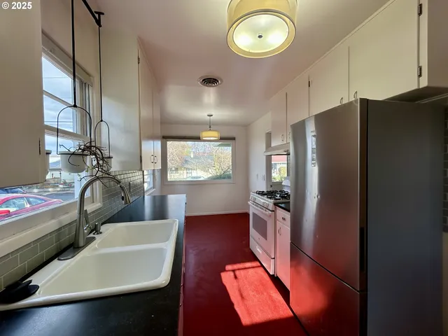 a view of a kitchen with refrigerator and workspace