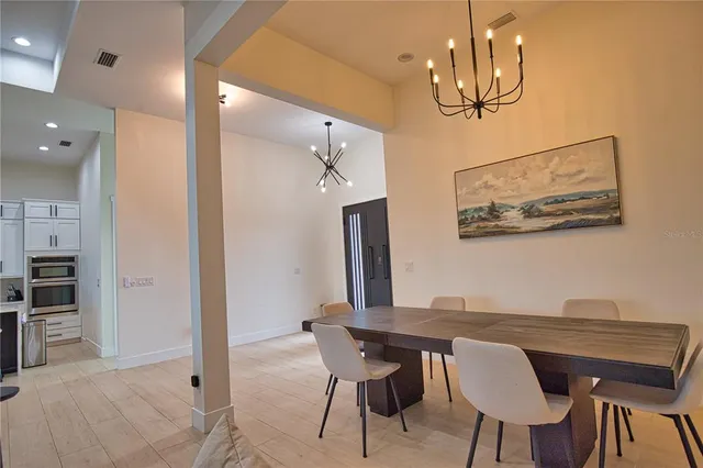 a view of a dining room with furniture and chandelier
