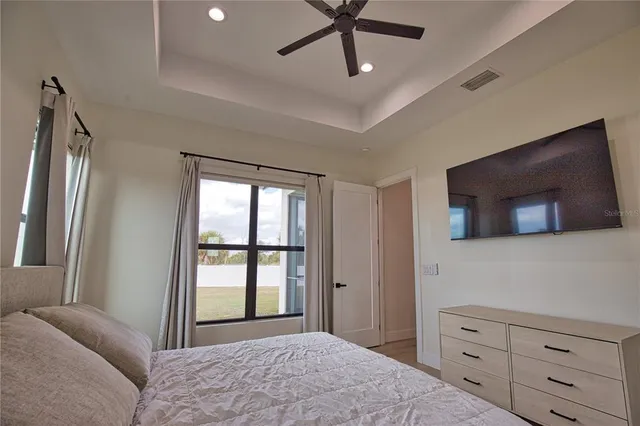 a bedroom with a large bed and a flat tv screen