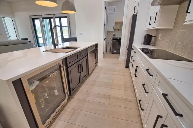 a kitchen with granite countertop a sink stove and refrigerator