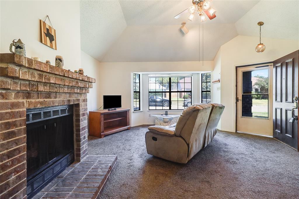 1728 Hackamore Street Mesquite, TX 75149 - Photo 5 of 22 Carpeted living area featuring a brick fireplace, a ceiling fan, and vaulted ceiling