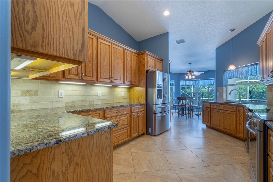 414 Ash Street Sebastian, FL 32958 - Photo 9 of 36 a kitchen with stainless steel appliances granite countertop a stove a sink and a microwave
