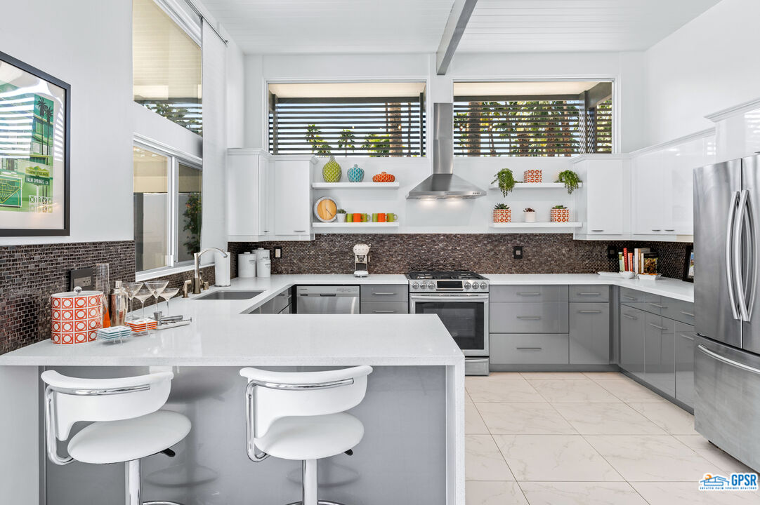 1008 Apache Road Palm Springs, CA 92264 - Photo 11 of 55 a kitchen with a stove a sink and a refrigerator