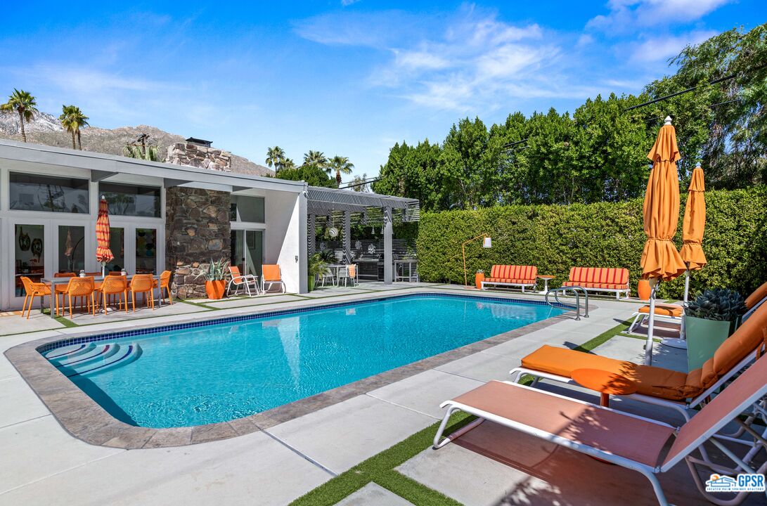 1008 Apache Road Palm Springs, CA 92264 - Photo 25 of 55 a view of a swimming pool with a lounge chairs in patio