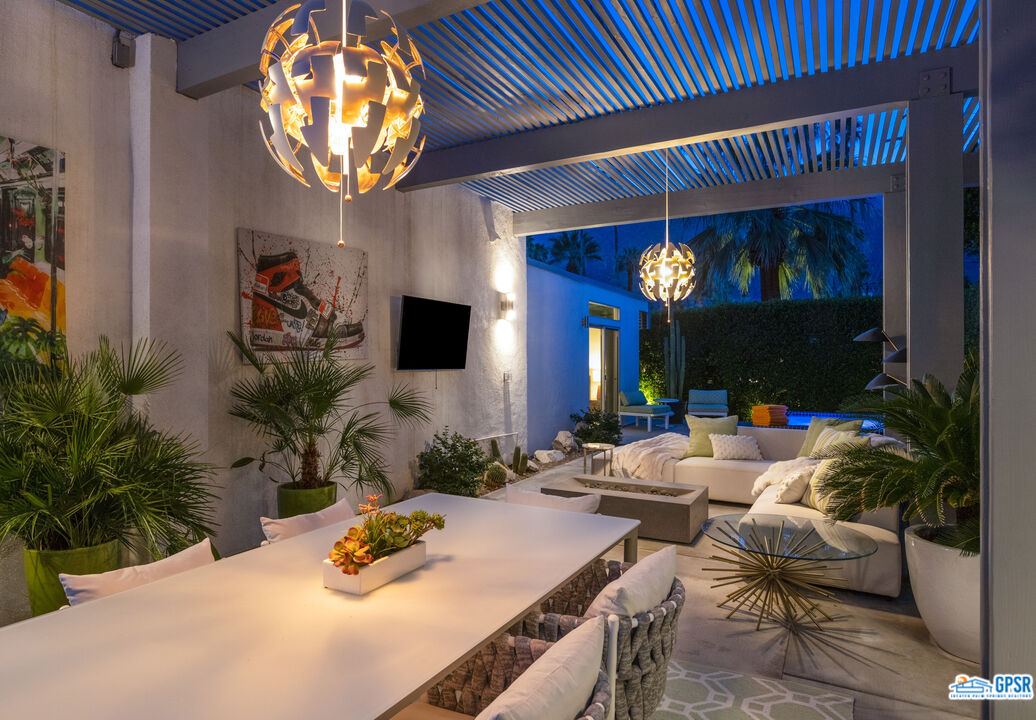 1008 Apache Road Palm Springs, CA 92264 - Photo 51 of 55 a living room with furniture a chandelier and a flat screen tv