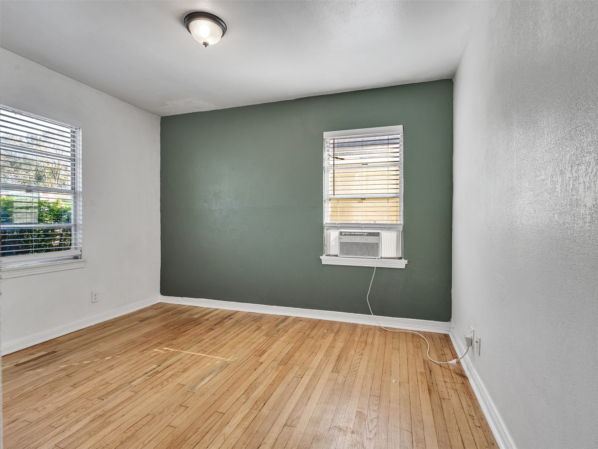 6942 Peyton Street Houston, TX 77028 - Photo 11 of 33 an empty room with wooden floor and windows