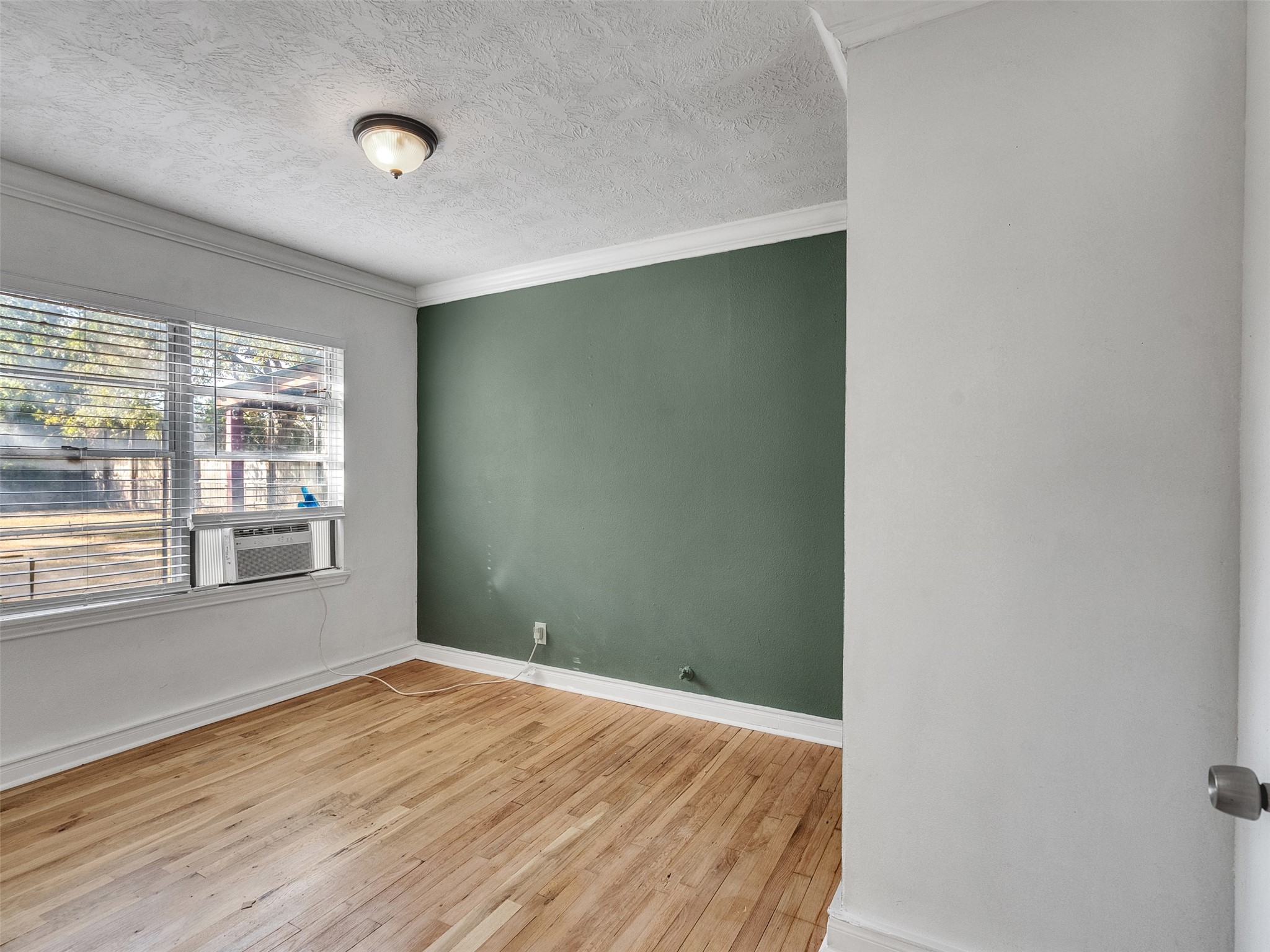 6942 Peyton Street Houston, TX 77028 - Photo 12 of 33 an empty room with wooden floor and windows