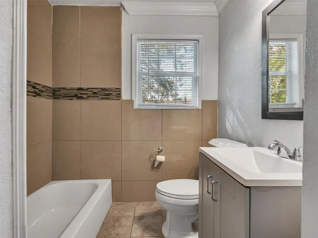 a bathroom with a sink a toilet and a window