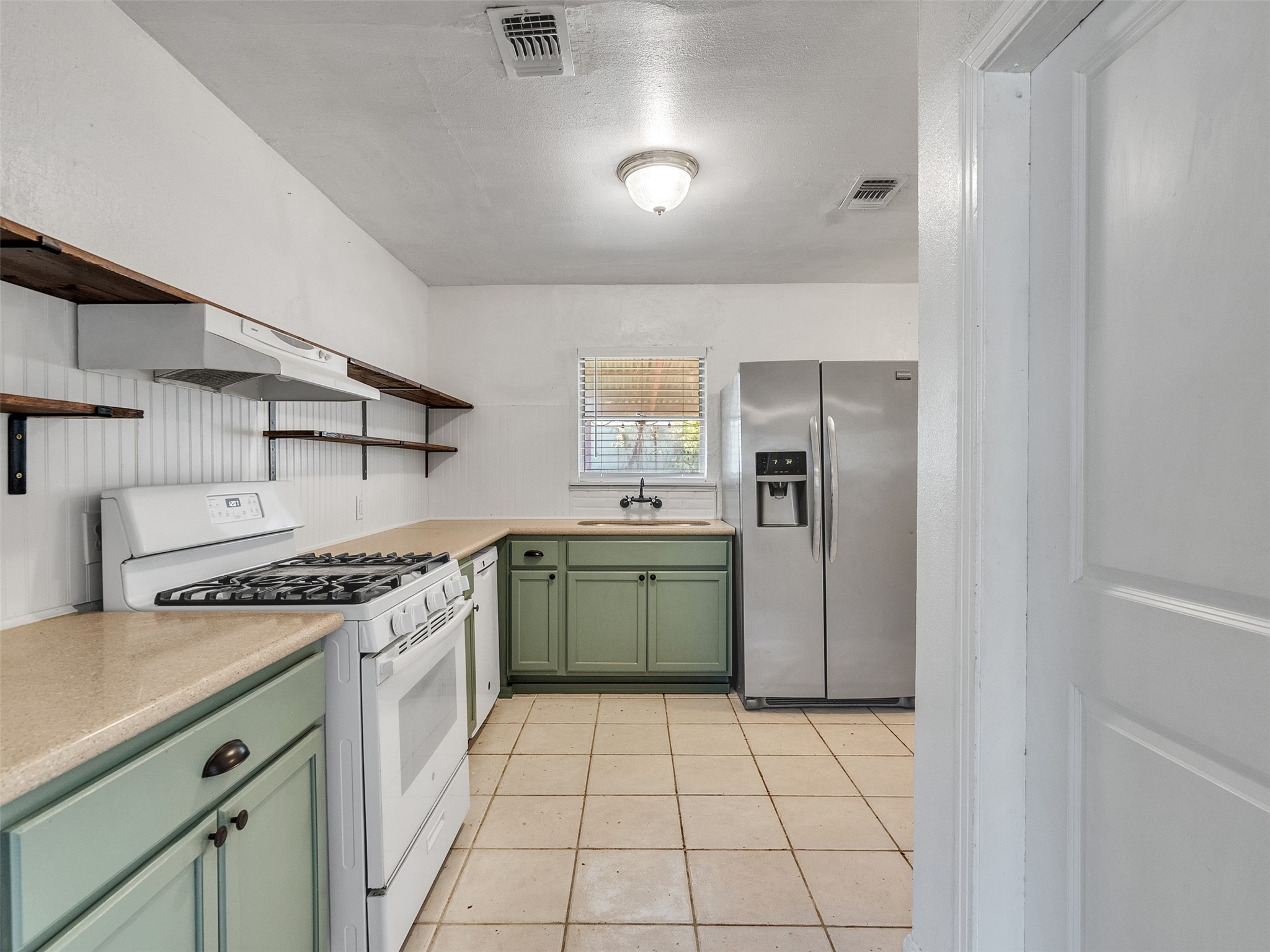 6942 Peyton Street Houston, TX 77028 - Photo 19 of 33 a kitchen with a stove top oven and cabinets