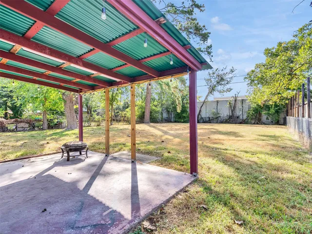a view of a patio with a table chairs and a backyard