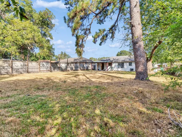 a view of yard with tree and wooden fence