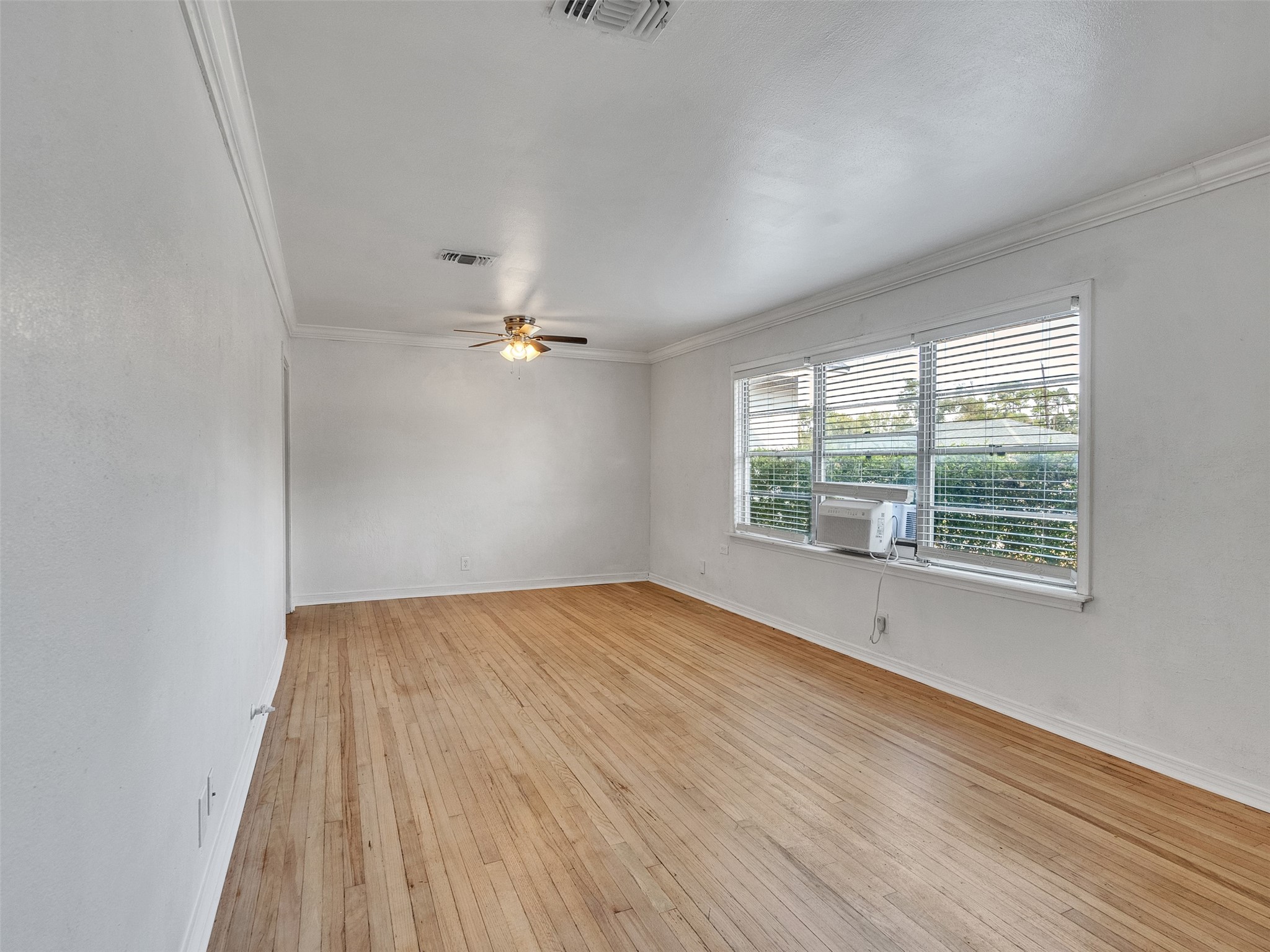 6942 Peyton Street Houston, TX 77028 - Photo 3 of 33 wooden floor in an empty room with a window