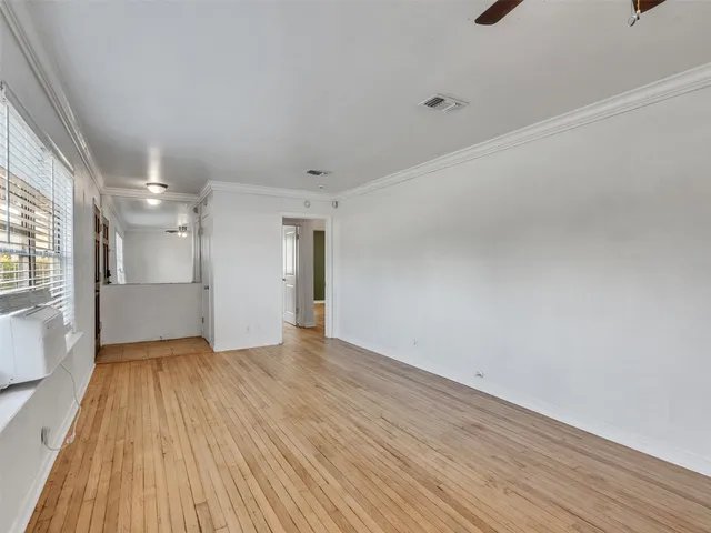 a view of a big room with wooden floor and windows