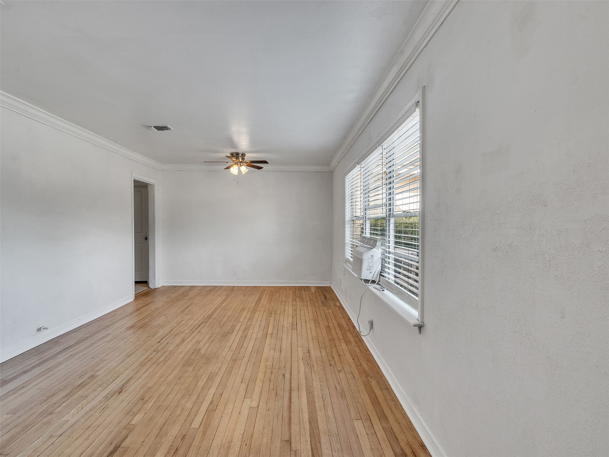 6942 Peyton Street Houston, TX 77028 - Photo 5 of 33 wooden floor in an empty room with a window