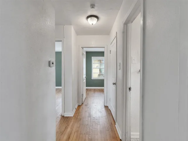 a view of a hallway with wooden floor