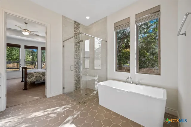 a spacious bathroom with a tub mirror and window