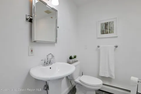 a bathroom with a sink toilet and a mirror