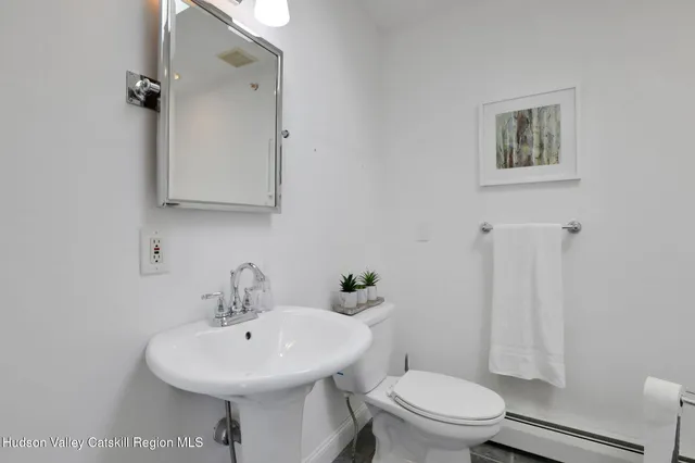 a bathroom with a sink toilet and a mirror