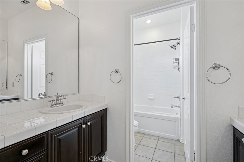 56 Fringe Tree Irvine, CA 92606 - Photo 15 of 26 a bathroom with a granite countertop sink a mirror and a shower