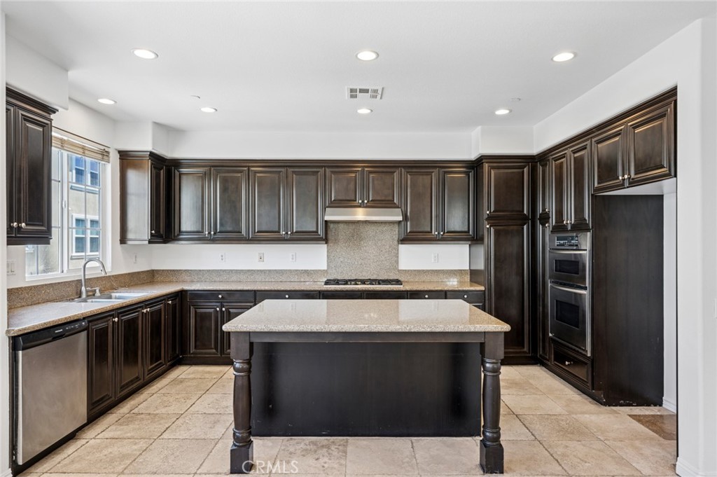 56 Fringe Tree Irvine, CA 92606 - Photo 9 of 26 a kitchen with stainless steel appliances granite countertop a stove and a refrigerator