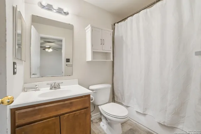 a bathroom with a sink a toilet and shower curtain