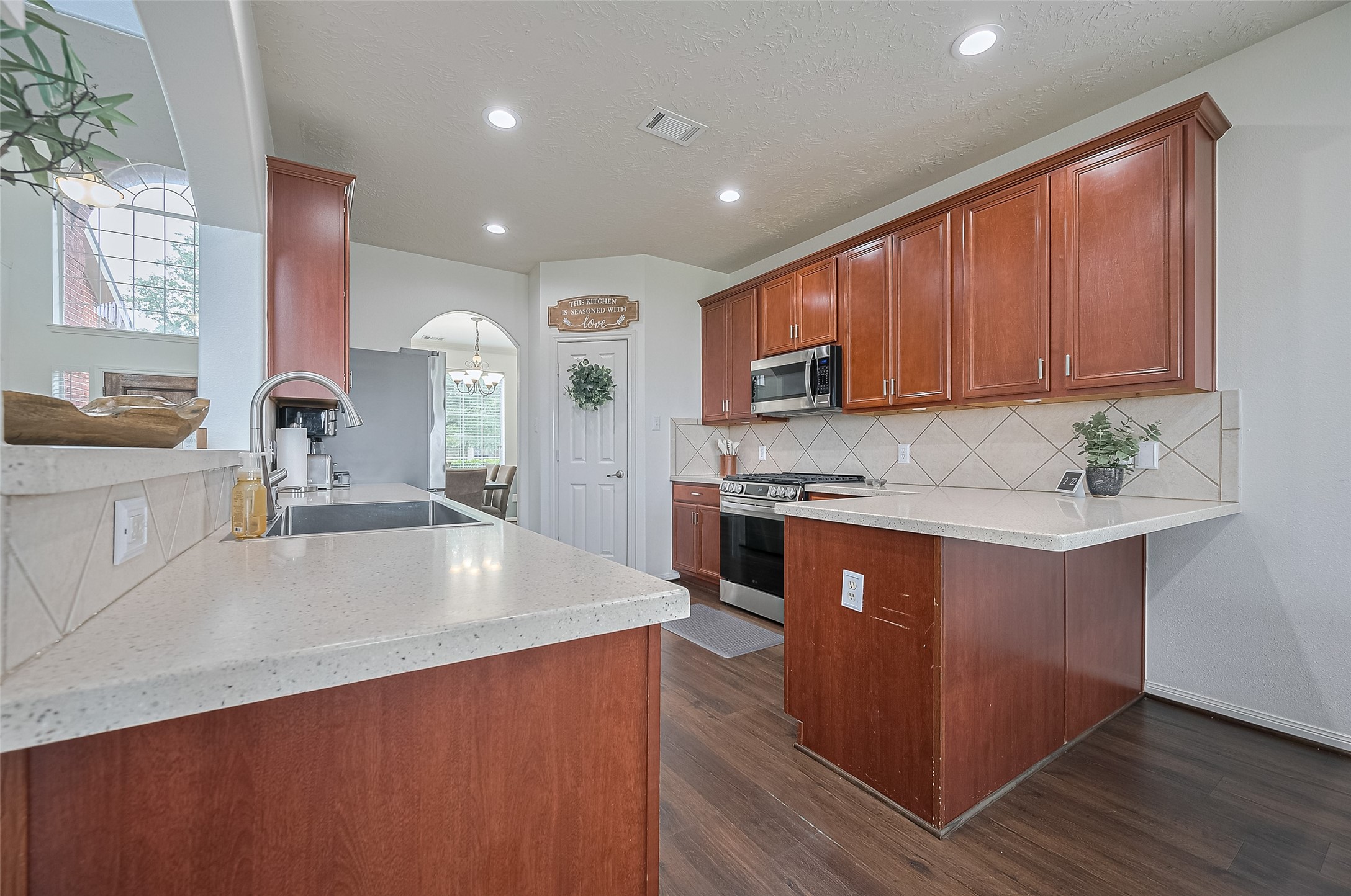 21506 Avalon Queen Drive Spring, TX 77379 - Photo 13 of 48 a large kitchen with stainless steel appliances a sink dishwasher a stove a microwave oven and cabinets with wooden floor