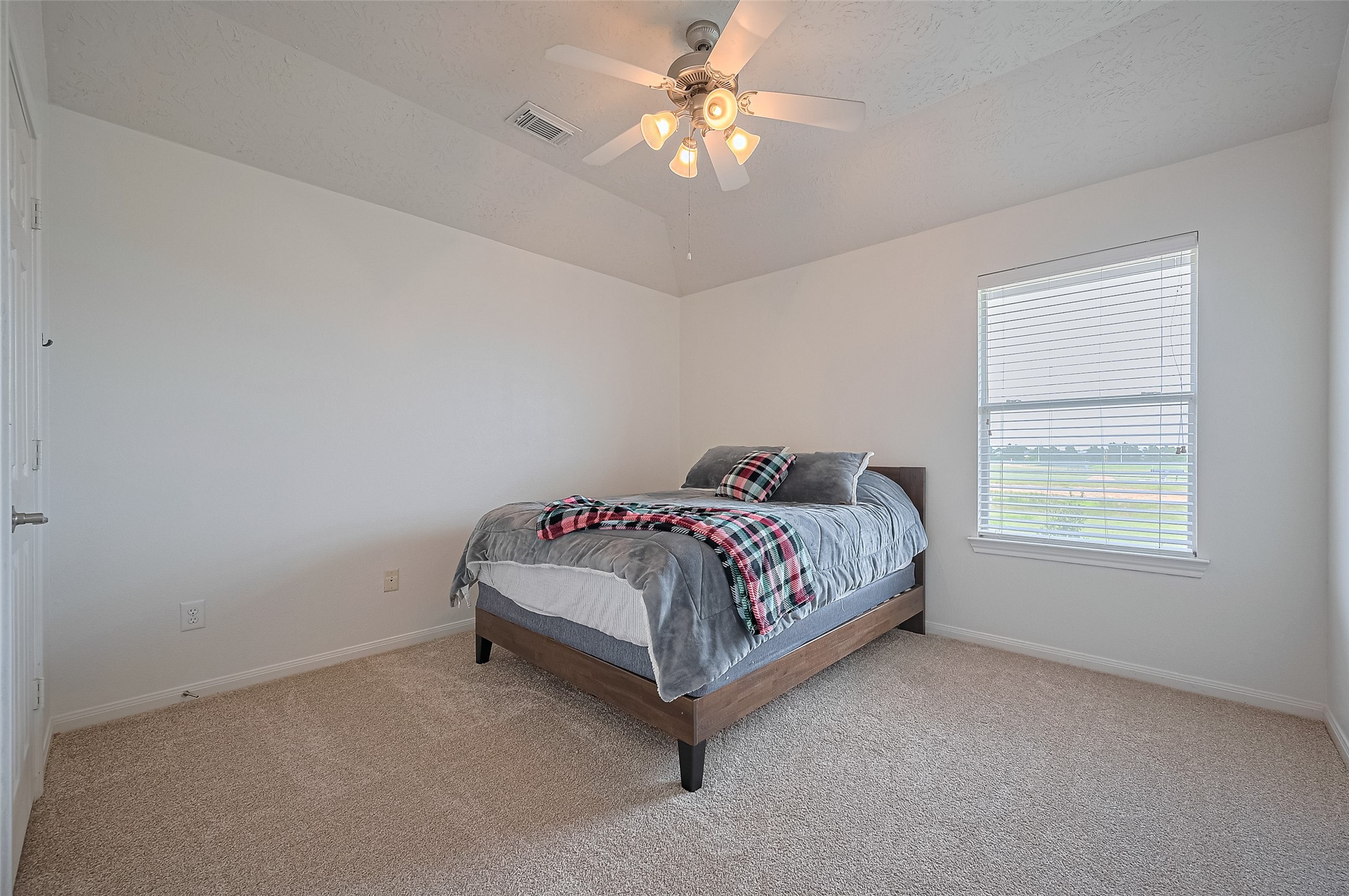 21506 Avalon Queen Drive Spring, TX 77379 - Photo 38 of 48 a bed sitting in a bedroom next to a window and a chandelier